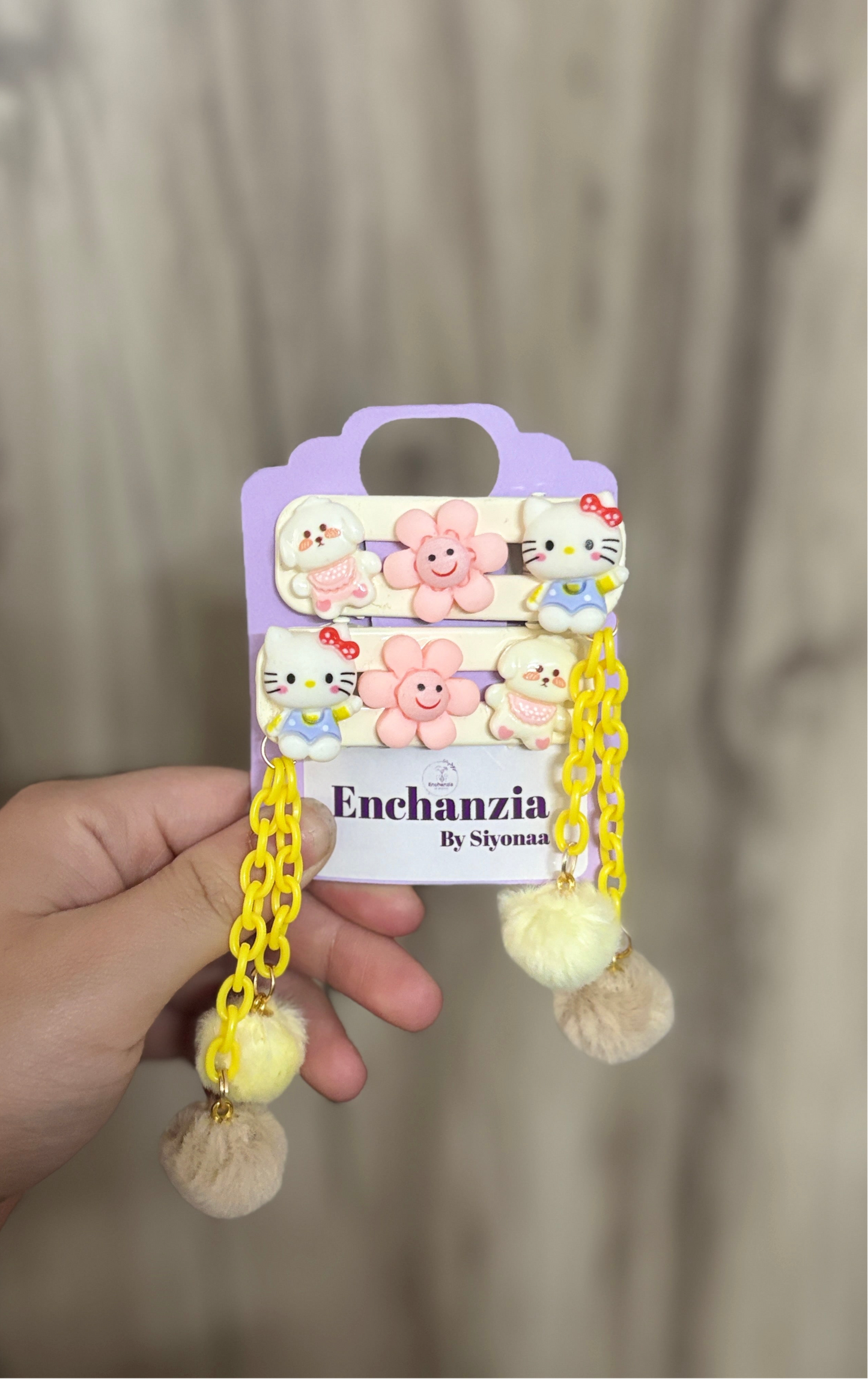 Pastel hair clips with Hello Kitty, happy flowers, a tiny bear, yellow chains, and fluffy Pom Poms. Perfect for adding charm to any hairstyle or outfit.