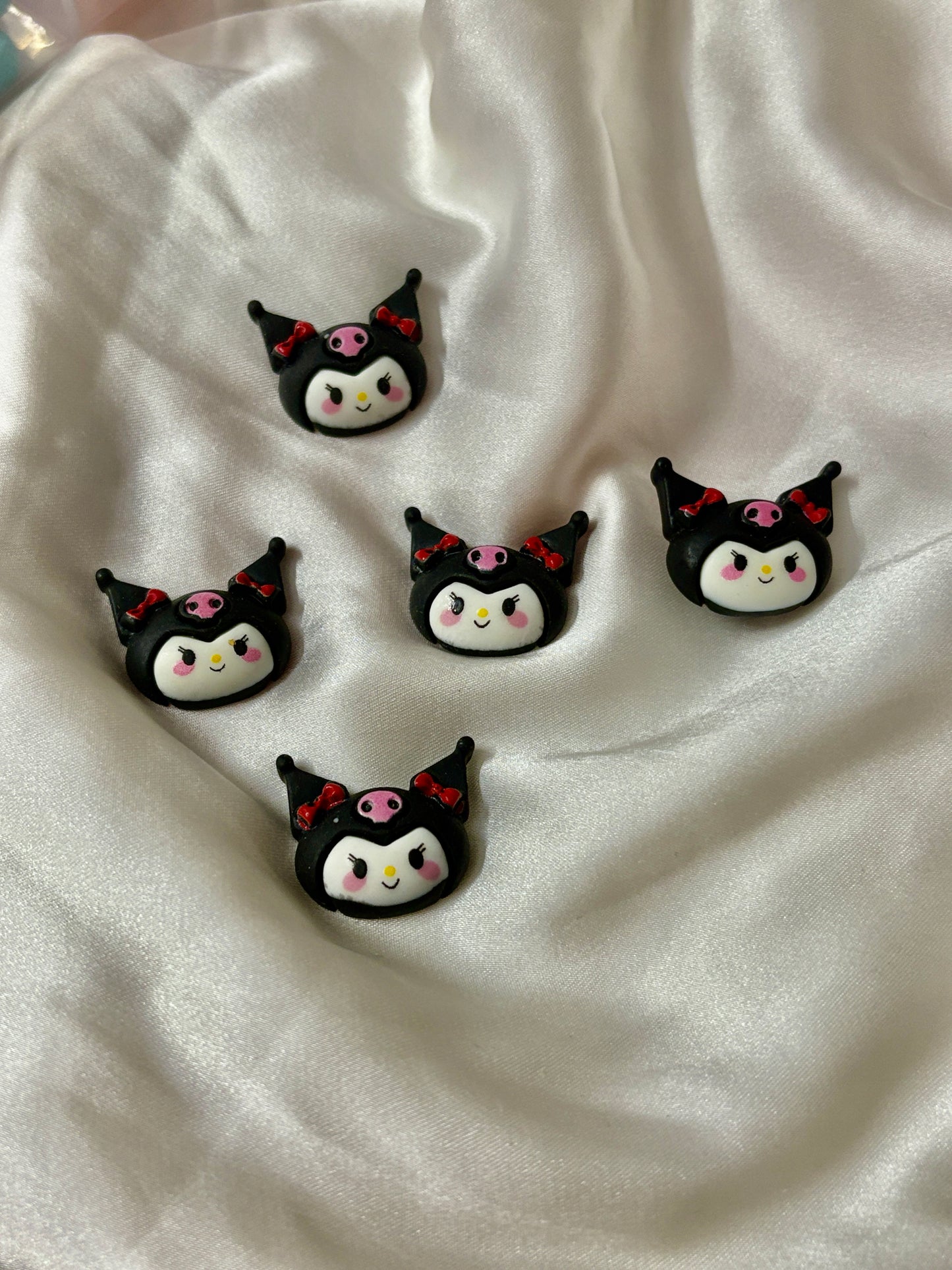 Single Kuromi Crocs Jibbitz charm in black with red bows and pink skull. Cute cartoon design ideal for fun and expressive Crocs styling.