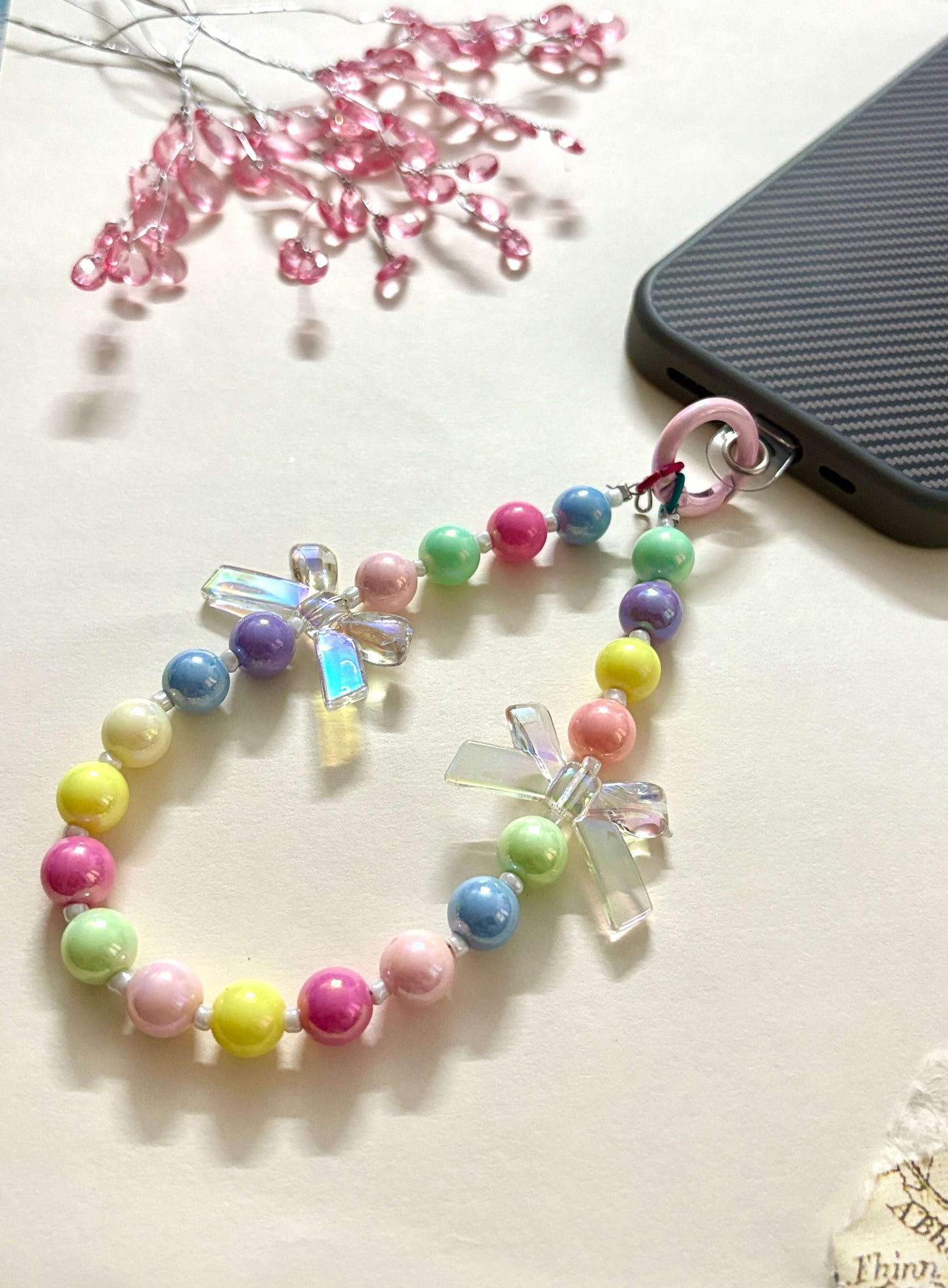 “Handmade colorful beaded phone charm with rainbow acrylic bow beads