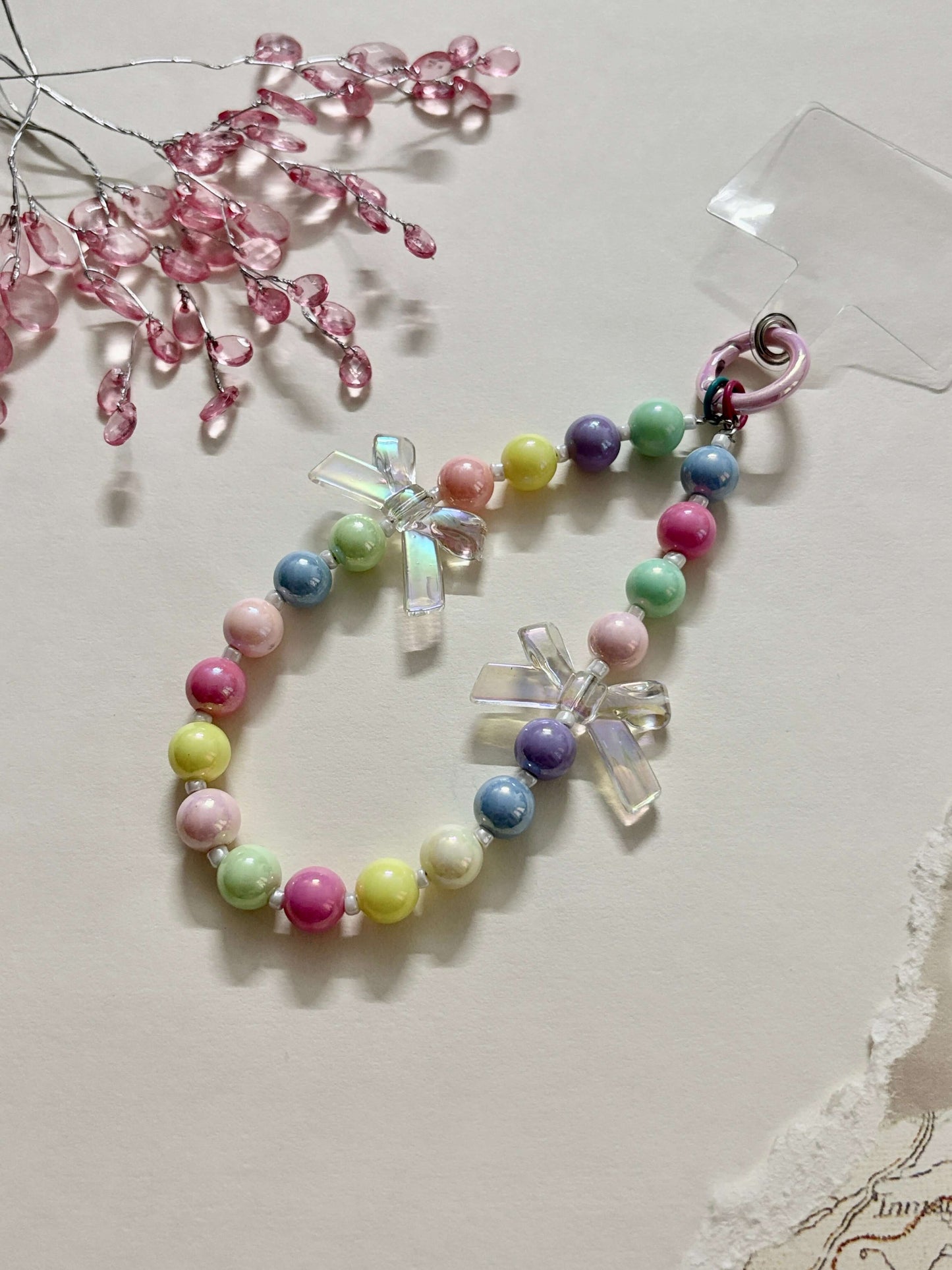 “Handmade colorful beaded phone charm with rainbow acrylic bow beads