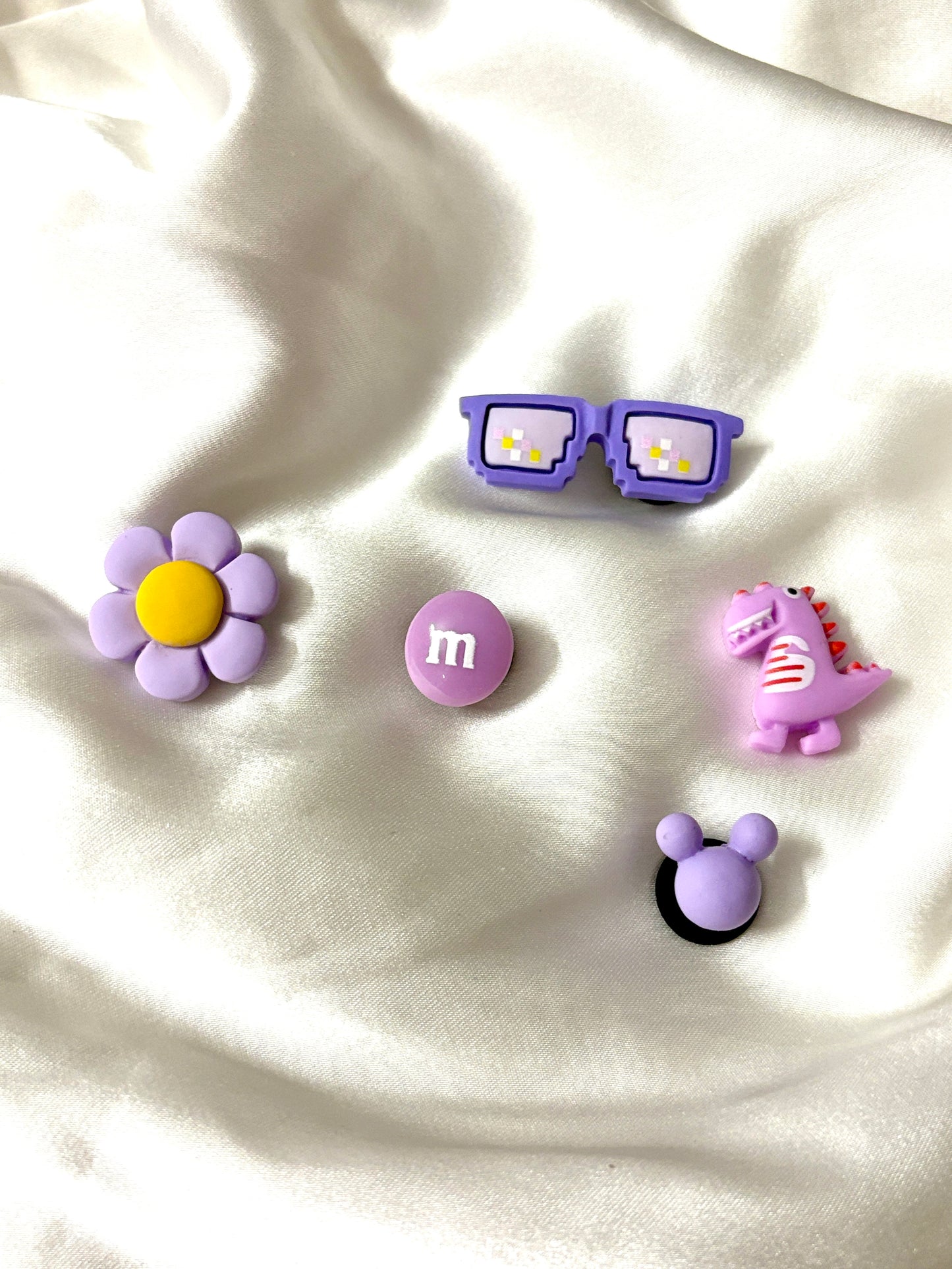Set of 5 Crocs Jibbitz charms in purple theme—includes glasses, flower, candy, dinosaur, and mouse ears. Colors may vary; assorted sets will be sent.