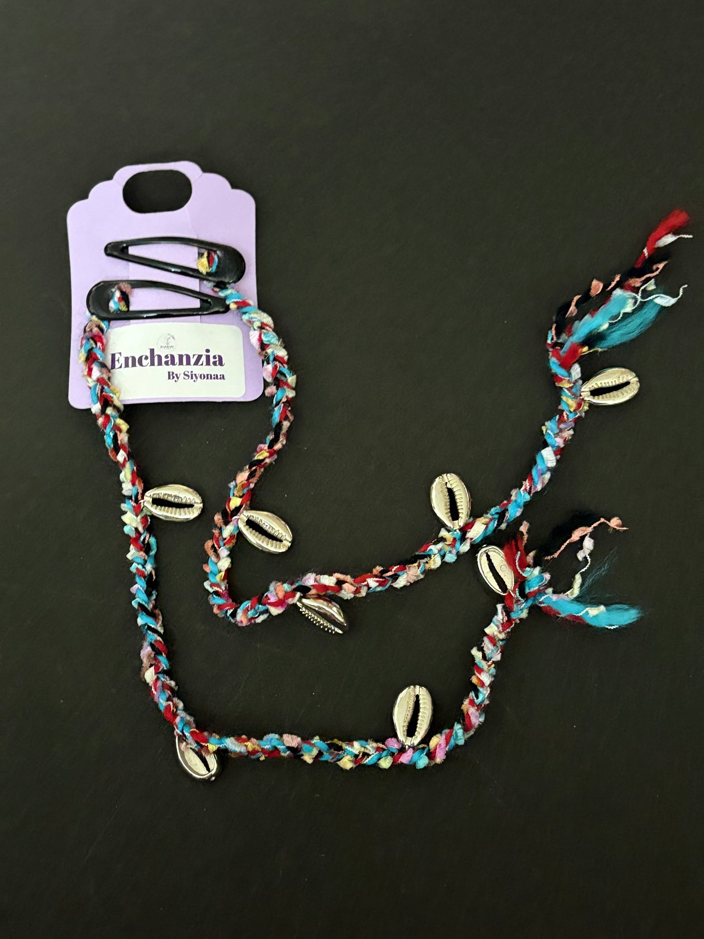 A vibrant handmade Goa-style hair braid woven with colorful threads and adorned with cowrie shells, braided into natural hair for a beachy, travel-inspired look.