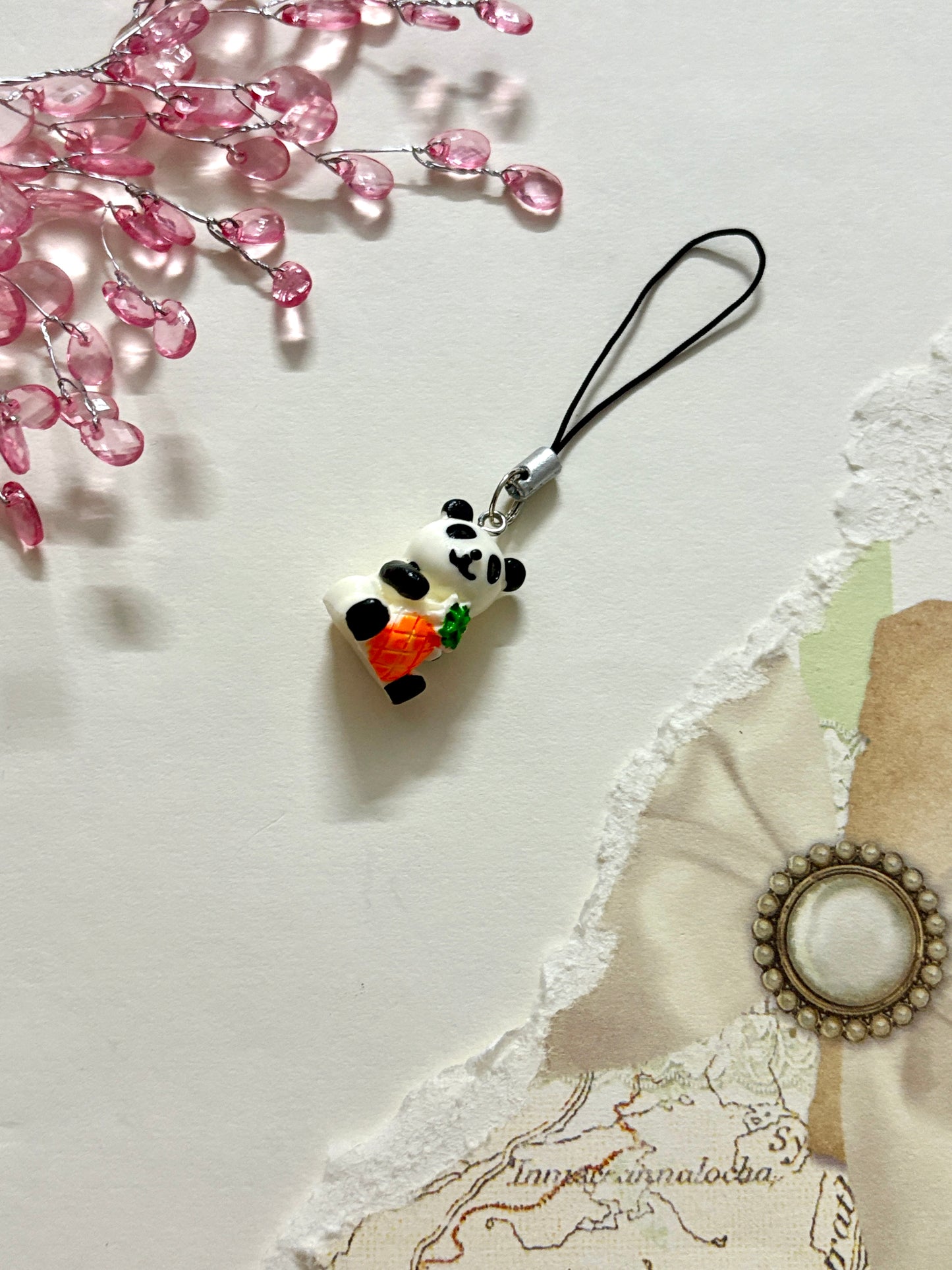 Handmade panda phone charm with black strap, featuring a cute panda holding a carrot — a fun and quirky accessory for phone cases, bags, or zippers.