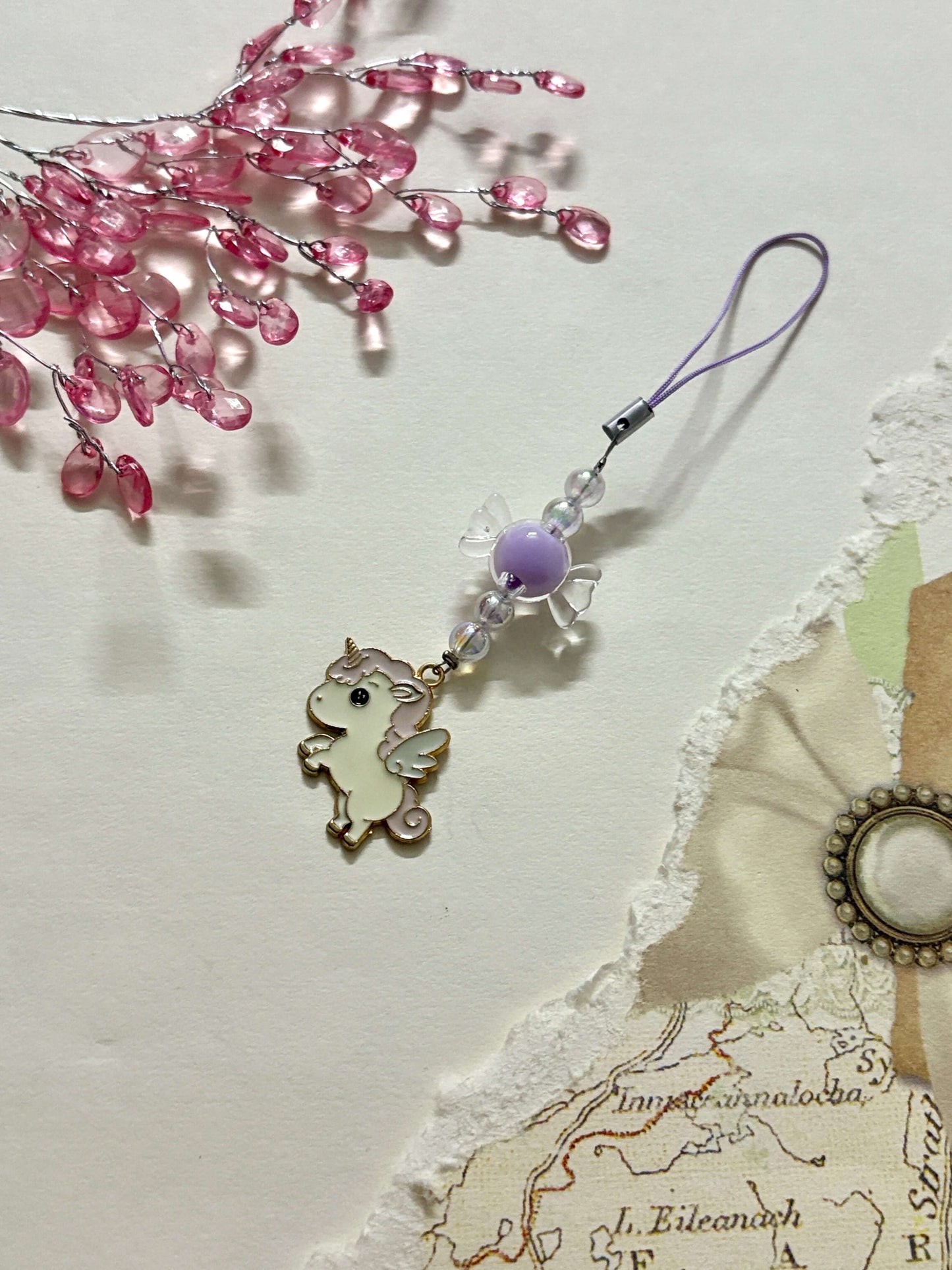 Adorable phone charm featuring a winged unicorn pendant paired with glossy beads and a loop strap, perfect for phones, keychains, or bags.