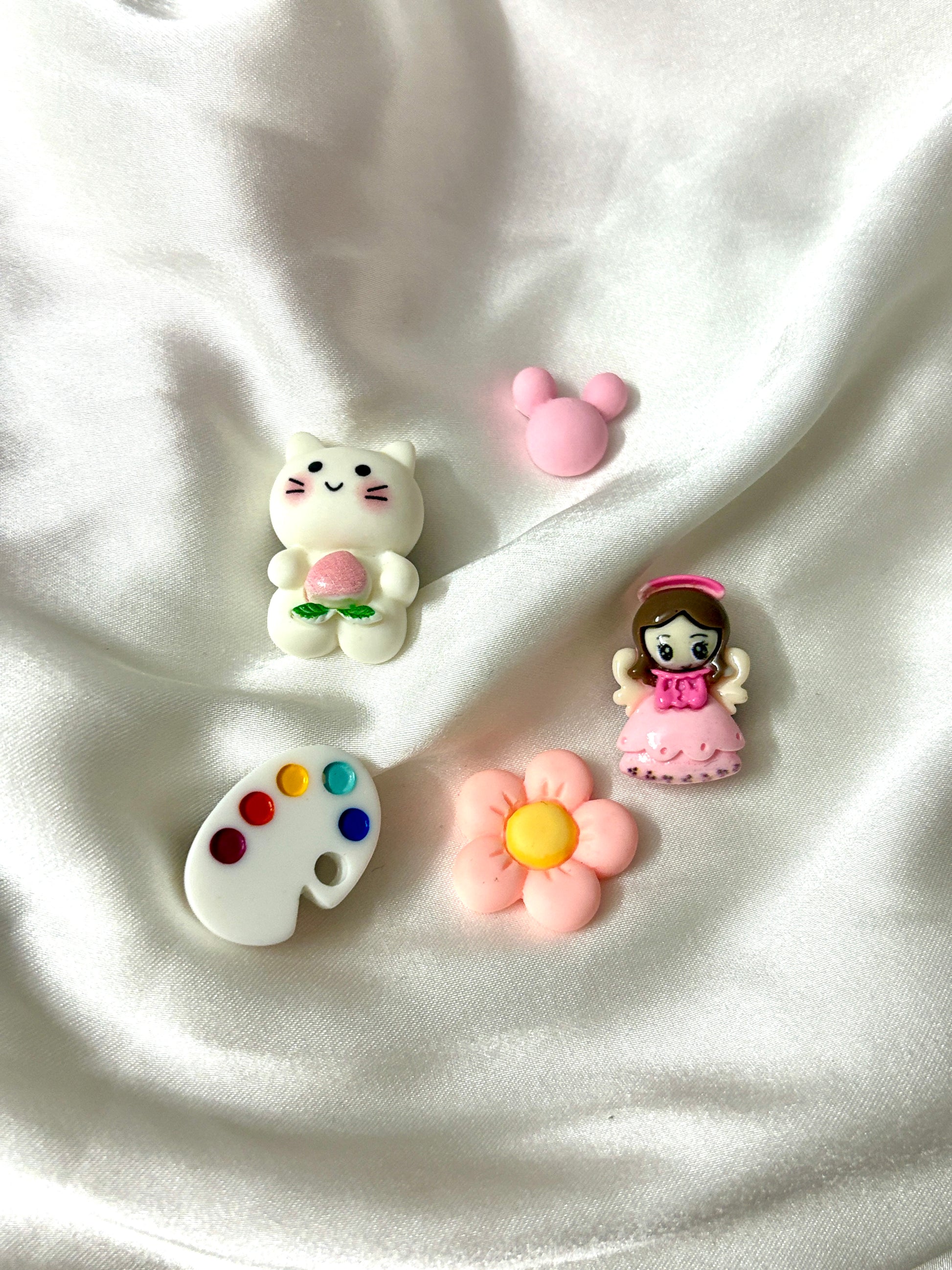 Set of 5 pastel Crocs Jibbitz with a cat, princess, flower, mouse head, and artist palette. Assorted colors will be included to create a playful mix.