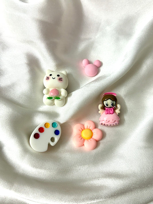 Set of 5 pastel Crocs Jibbitz with a cat, princess, flower, mouse head, and artist palette. Assorted colors will be included to create a playful mix.