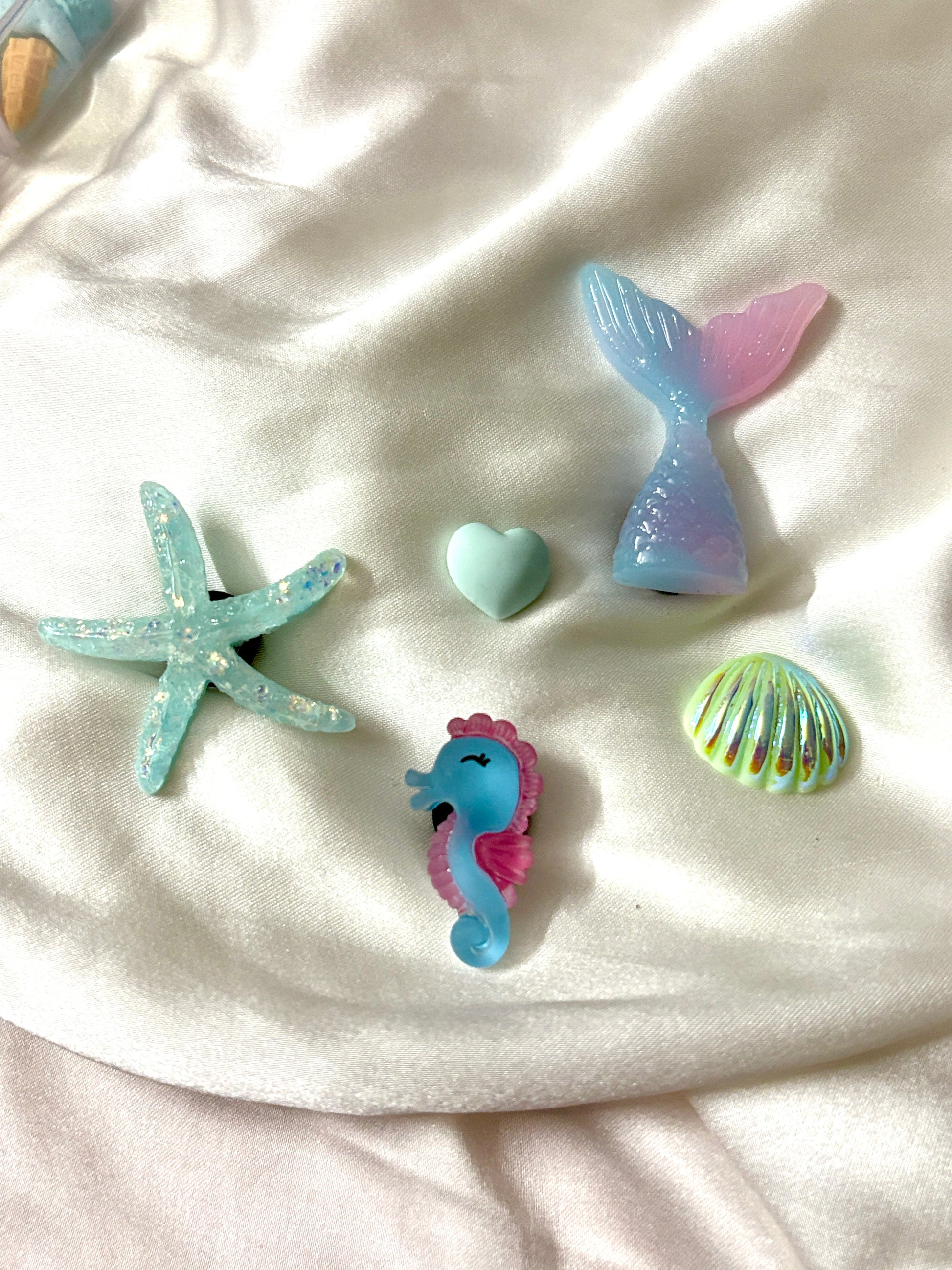 Set of 5 pastel ocean Crocs Jibbitz charms featuring a mermaid tail, glitter starfish, cute seahorse, seashell, and heart—perfect for a soft beachy vibe.