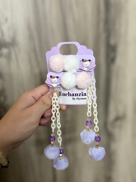 Cute purple Pom Pom hair clips with white chains, beads & soft fluff balls—adorable kids’ hair accessory shown on display and styled on dark hair.