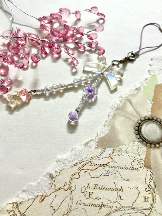 Beaded phone charm with iridescent bow, bear bead, and floral accents. A delicate and whimsical accessory ideal for bags, phones, or gifting.