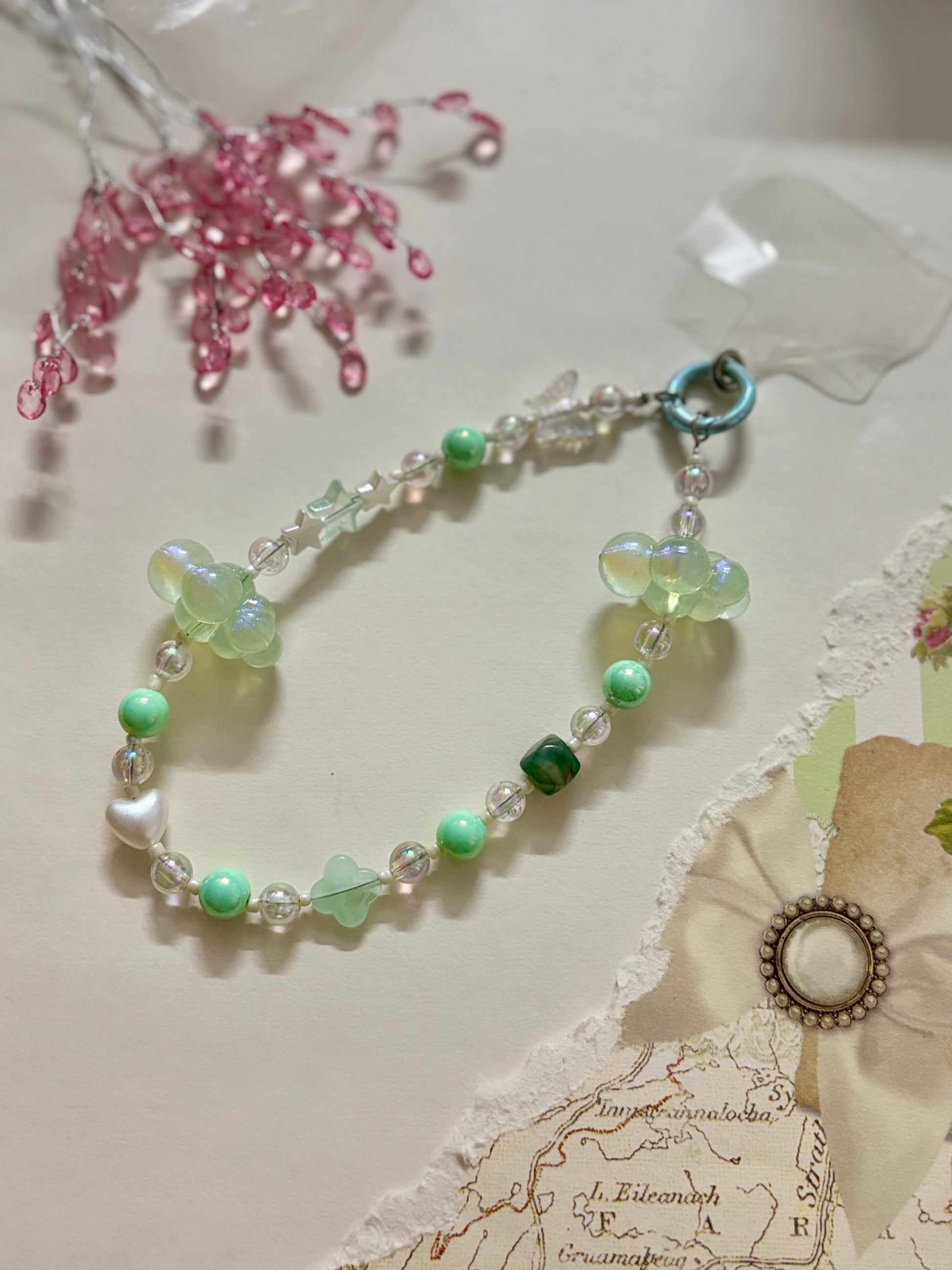 Aesthetic beaded phone charm featuring translucent clouds, a navy star, pastel beads, and butterfly accents, arranged in a dreamy celestial theme.