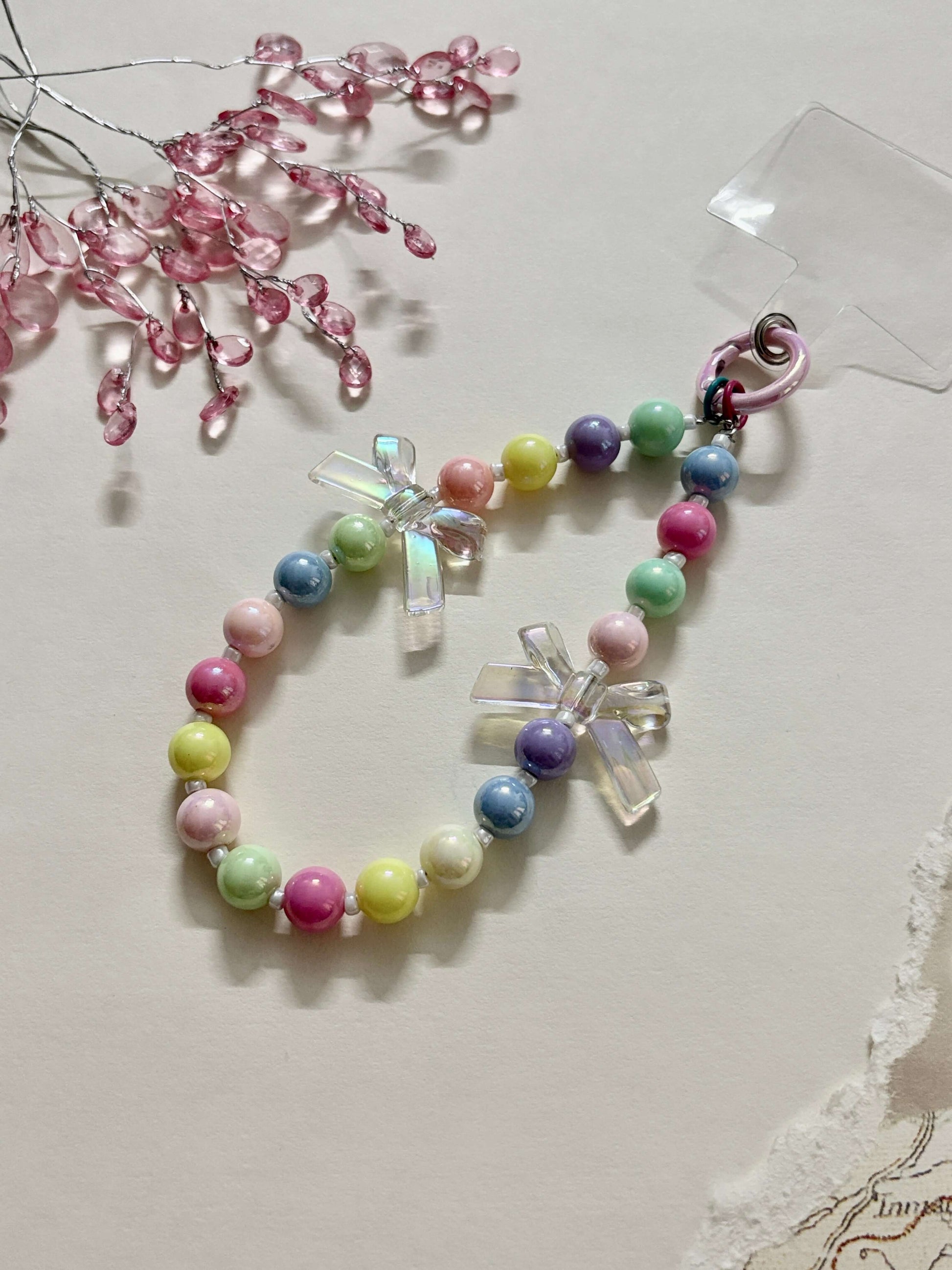 “Handmade colorful beaded phone charm with rainbow acrylic bow beads