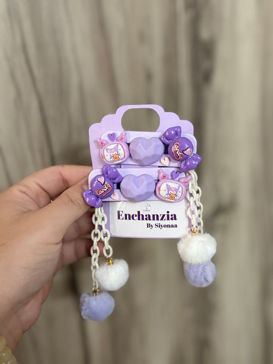 Set of purple kawaii Kuromi hair clips with heart, candy, and Kuromi designs. Decorated with chains and fluffy pom-poms. Fun accessory from Enchanzia by Siyonaa.
