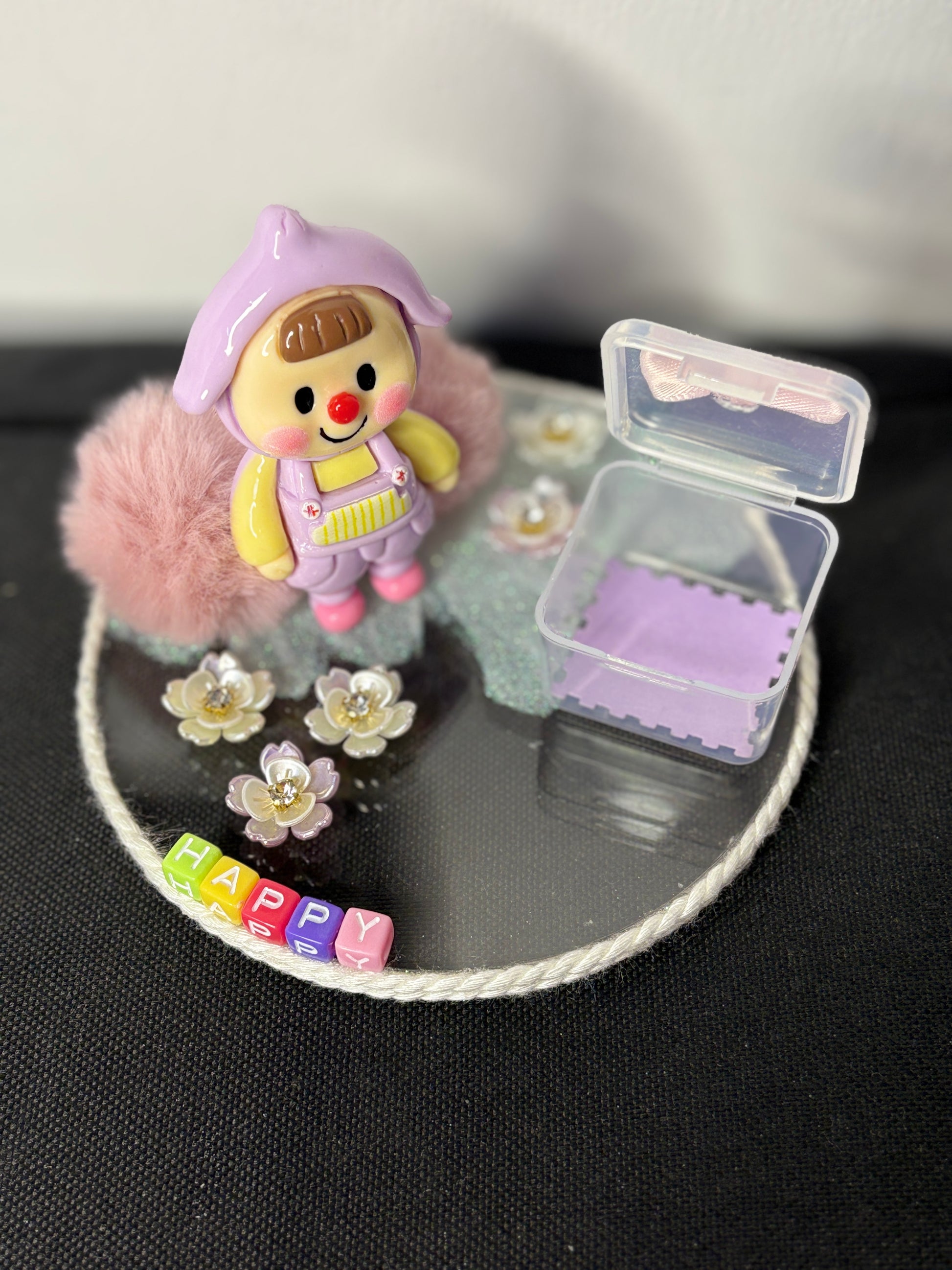 A decorative miniature platter featuring a baby-themed character, floral charms, fuzzy elements, and a small storage box with a bow; ideal for organizing rings, earrings, candies, or trinkets—perfect as a gift or tabletop accessory.
