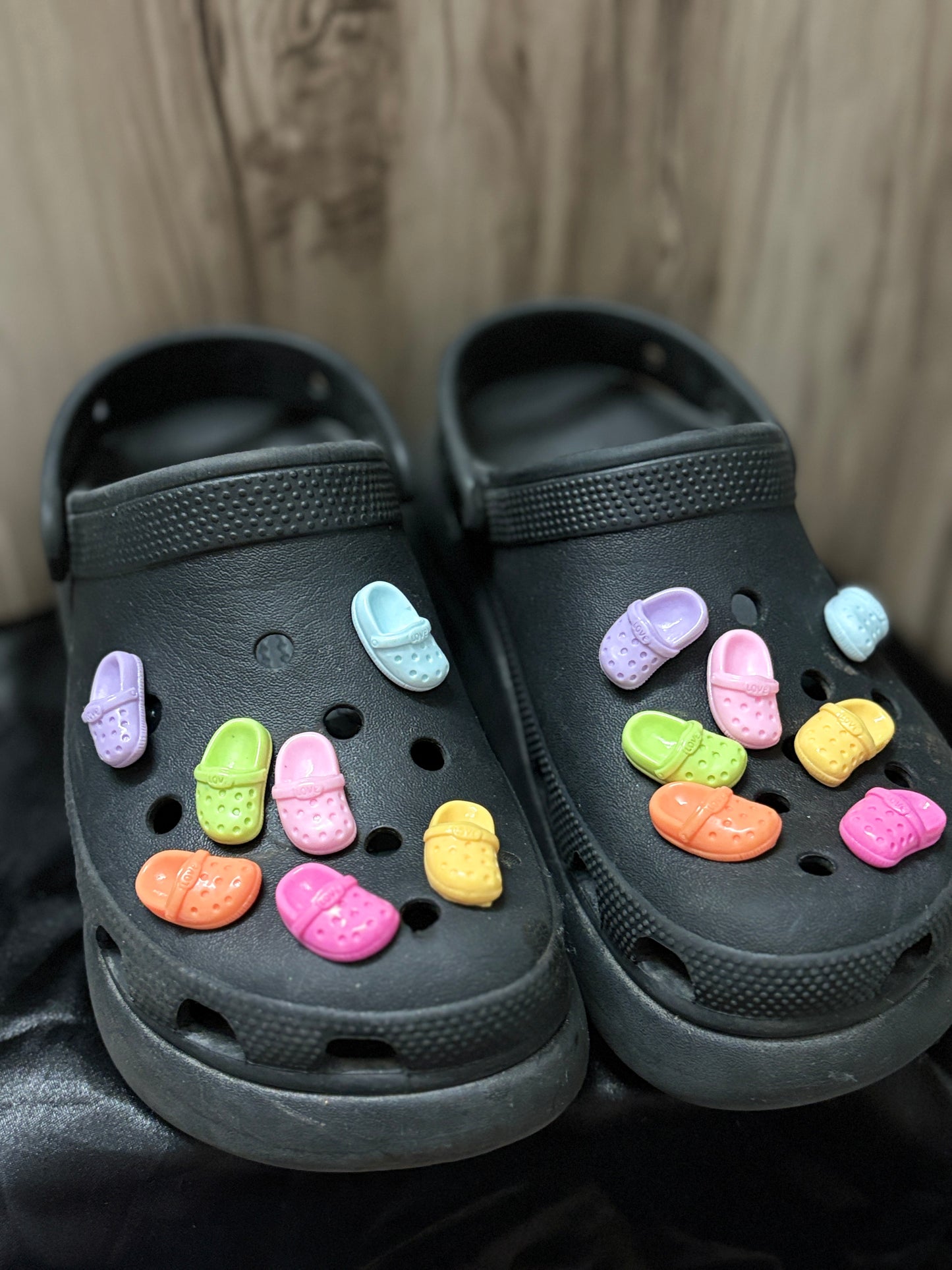 Colorful Crocs-shaped Jibbitz charms in matching pairs, with vibrant shades like pink, blue, yellow, black, and more—perfect for a quirky Crocs upgrade.

