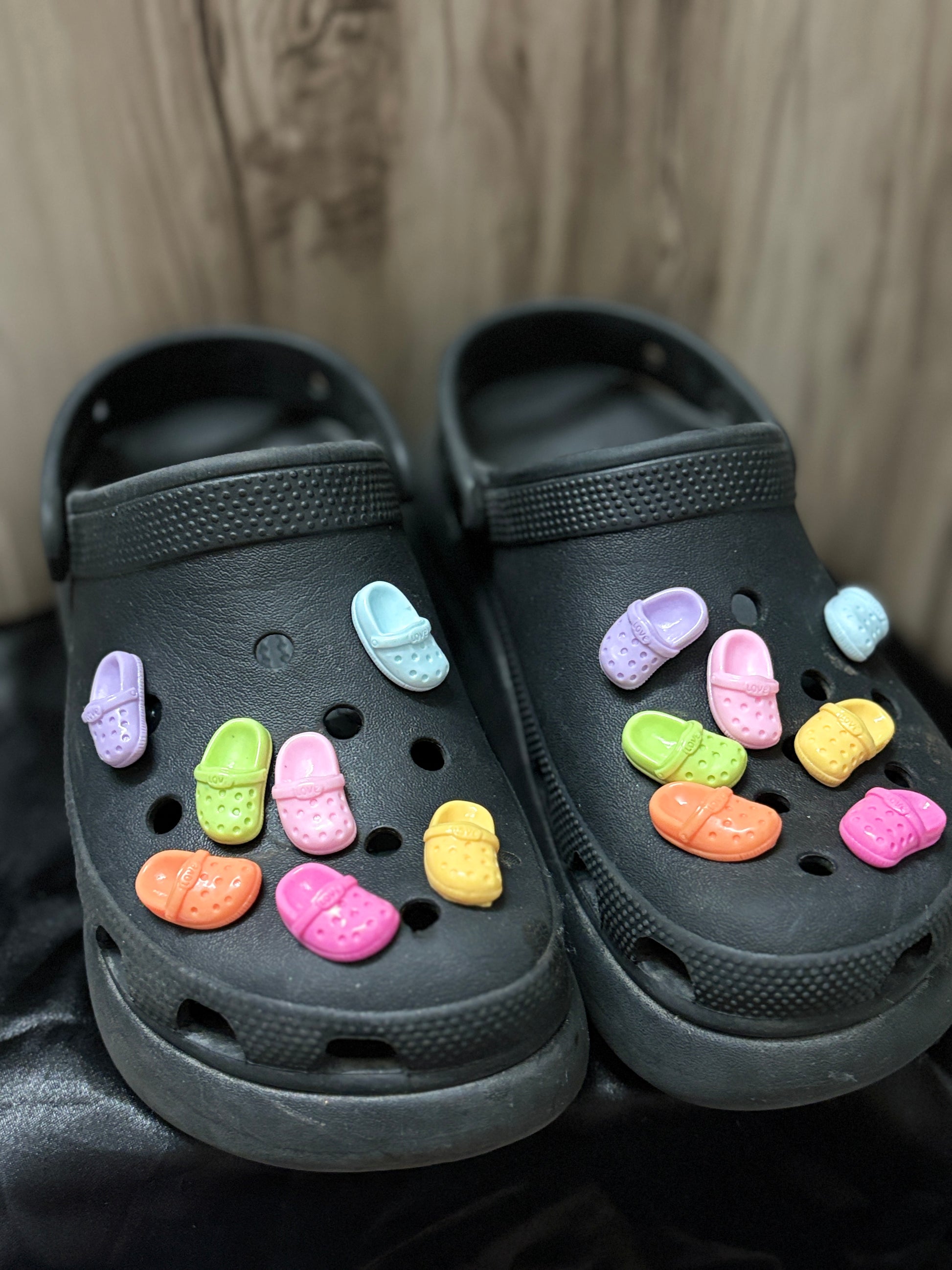 Colorful Crocs-shaped Jibbitz charms in matching pairs, with vibrant shades like pink, blue, yellow, black, and more—perfect for a quirky Crocs upgrade.
