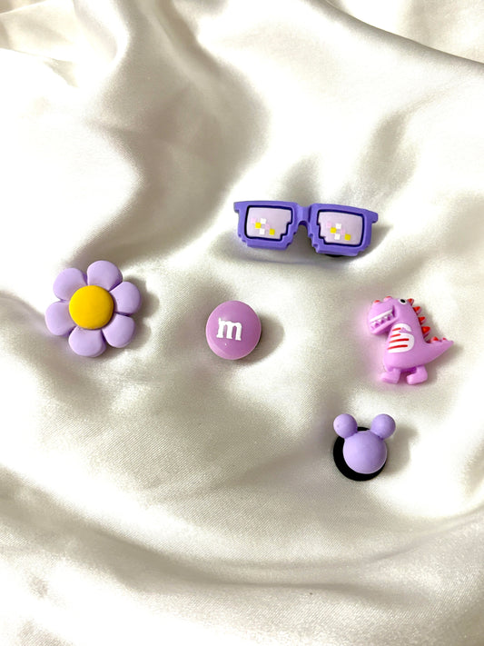 Set of 5 Crocs Jibbitz charms in purple theme—includes glasses, flower, candy, dinosaur, and mouse ears. Colors may vary; assorted sets will be sent.