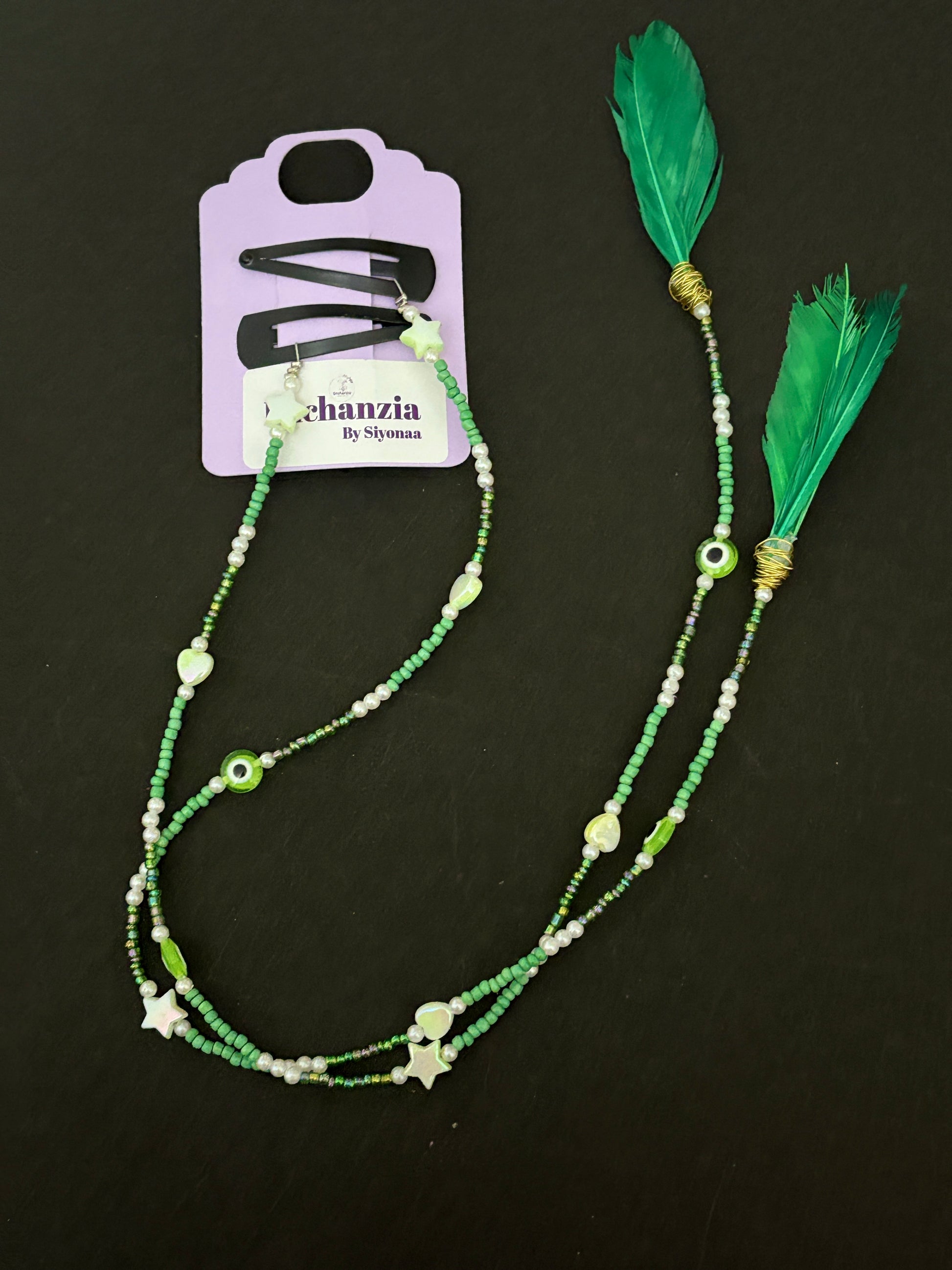 A handmade bohemian-style hair braid decorated with small beads and shaped charms, clipped into natural hair for a free-spirited, festival-ready look.

