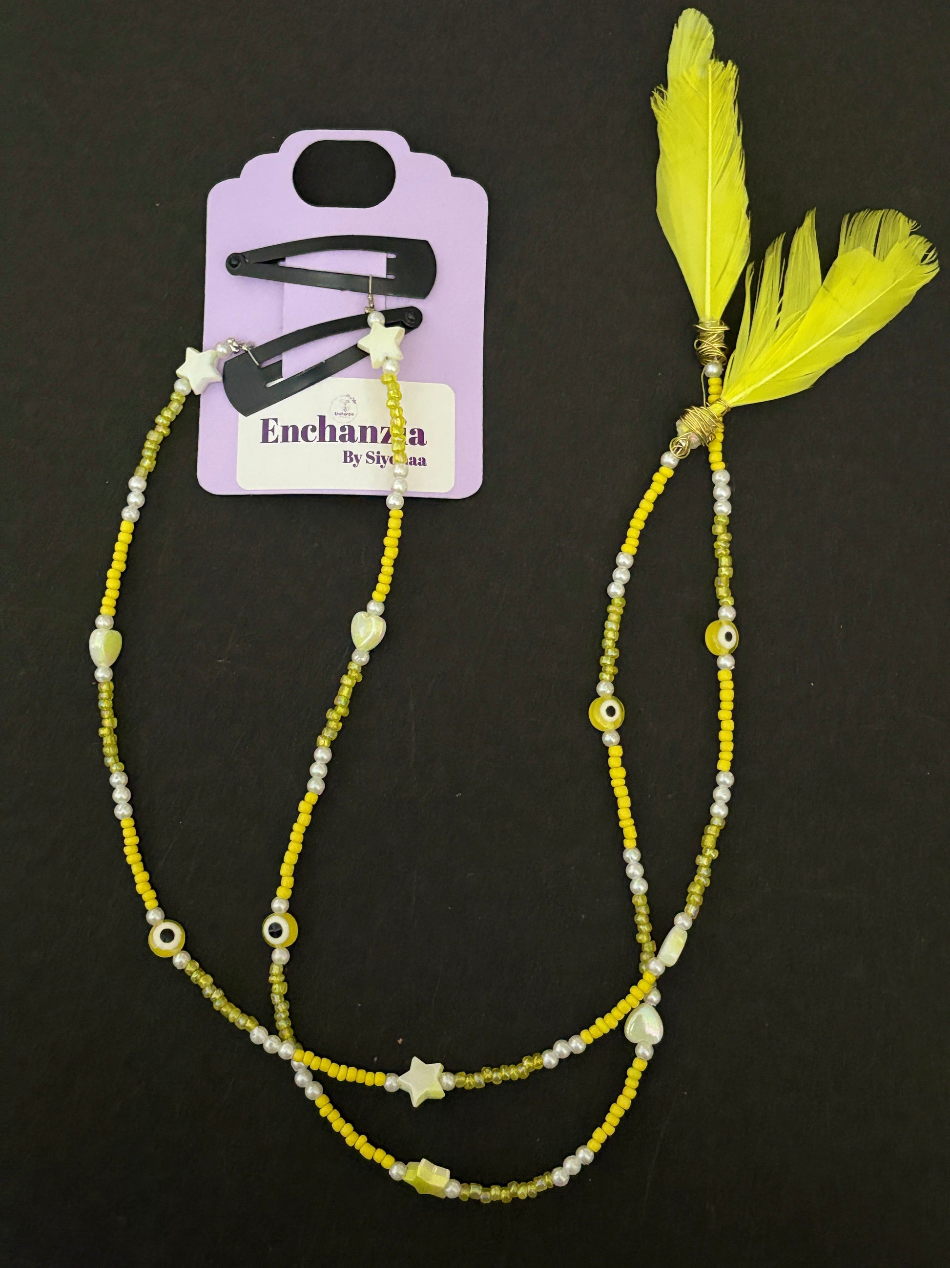 A handmade bohemian-style hair braid decorated with small beads and shaped charms, clipped into natural hair for a free-spirited, festival-ready look.
