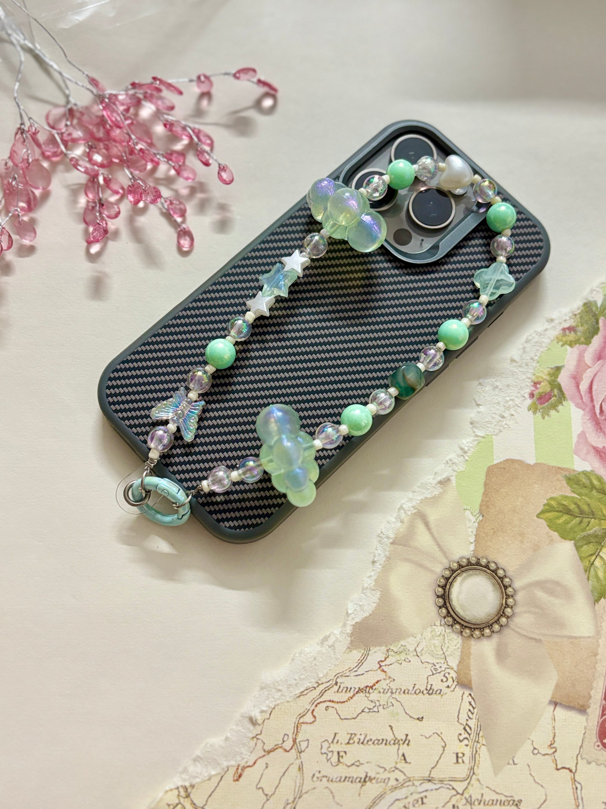Aesthetic beaded phone charm featuring translucent clouds, a navy star, pastel beads, and butterfly accents, arranged in a dreamy celestial theme.