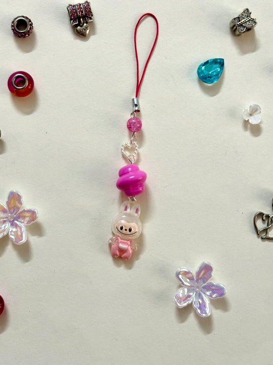 Mini Labubu phone charm with rainbow orb bead and black strap, featuring Labubu in blue overalls — collectible strap available in two color options.