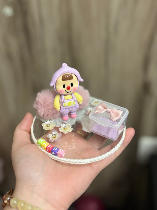A decorative miniature platter featuring a baby-themed character, floral charms, fuzzy elements, and a small storage box with a bow; ideal for organizing rings, earrings, candies, or trinkets—perfect as a gift or tabletop accessory.
